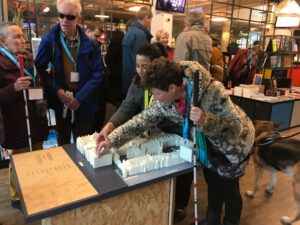 Foto: Blinden en slechtzienden bezoekers verkennen de omgevingsmaquette van het Buitenhof bij het huis voor de democratie.