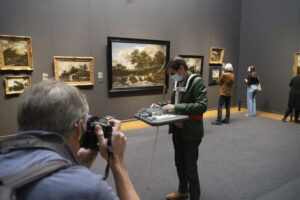 Blinde man test de draagbare maquette uit in het Rijksmuseum