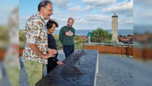 Vincent Bijlo staat met twee andere personen naast de bronzen maquette van Terschelling.