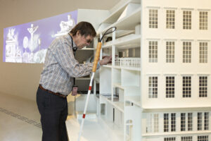 Blinde man verkent met zijn handen de maquette van Museum Ons' Lieve Heer op Solder.