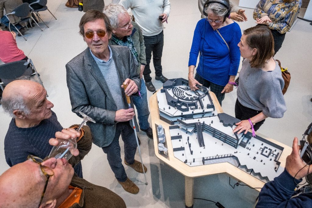 Een groep belangstellende staan opgesteld rond de maquette van de tweede kamer