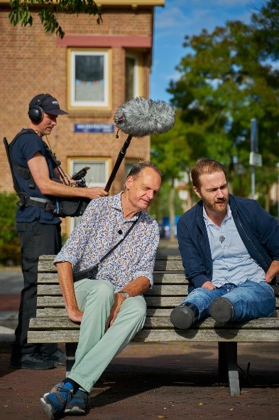 Vincent Bijlo en Thomas Schellens in gesprek zittend buiten op een bank